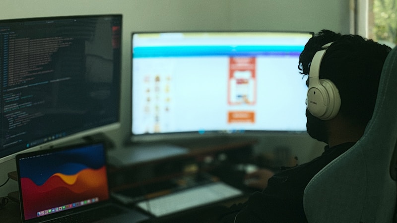 A person working across multiple monitors in a home office