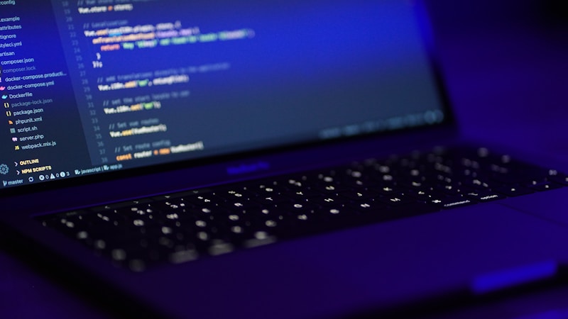 A developer coding on a laptop with a blue screen