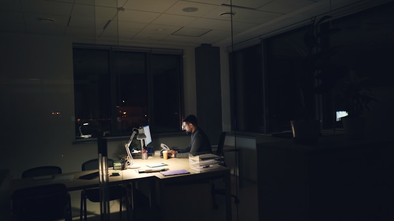 A founder working alone late at night at a dimly lit desk